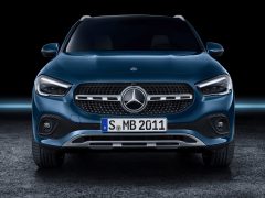 Vooraanzicht van een blauwe Mercedes-Benz GLA-auto tegen een donkere achtergrond.