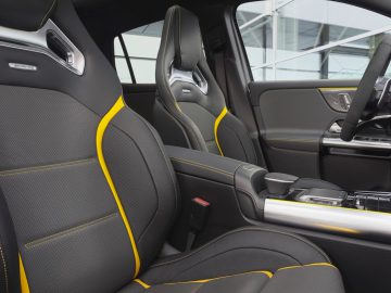 Luxe Mercedes-AMG GLA 45 4MATIC+ interieur met zwart en geel lederen stoelen en modern dashboard.
