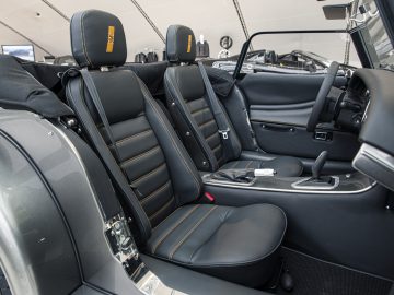 Binnenaanzicht van een Morgan-auto met de voorstoelen, middenconsole en dashboard.