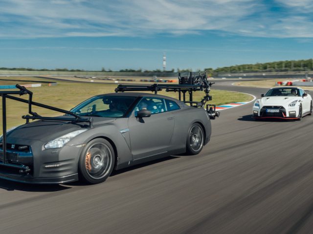 Twee auto's op een racecircuit, één uitgerust met een camera-installatie die de andere Nissan GT-R filmt.
