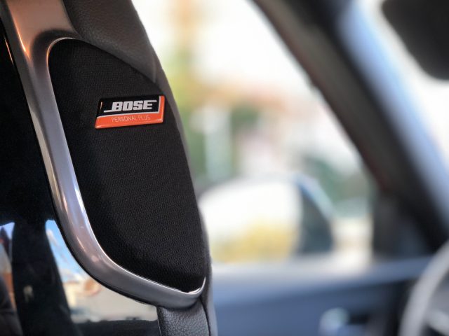 Auto-interieur van een Nissan Juke met de focus op een Bose-audiosysteemlabel op een hoofdsteun.