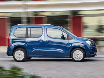 Een blauwe Opel-bestelwagen in beweging met een bewegingsonscherpteachtergrond die de snelheid aangeeft.