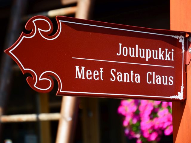 Een rood Subaru-bord met de tekst "joulupukki meet santa claus" geeft een locatie aan waar bezoekers de kerstman kunnen ontmoeten.