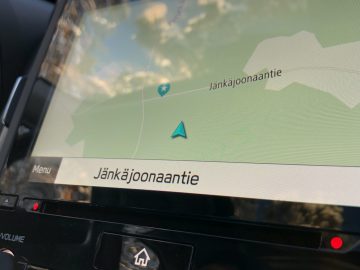 Voertuignavigatiesysteem in een Subaru Forester met een kaart met een blauwe pijl die de locatie op de "jänkäjoonaantie"-weg aangeeft.