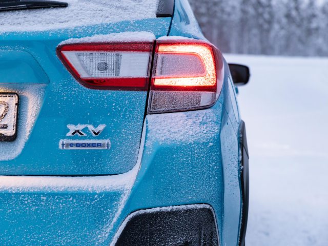 Blauwe Subaru XV e-Boxer met sneeuwophoping aan de achterkant, waardoor het achterlicht en de badges beter uitkomen.