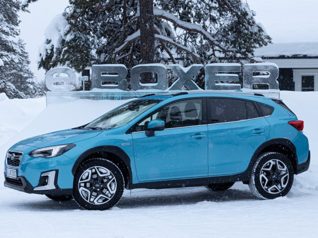 Blauwe Subaru XV e-Boxer geparkeerd in de sneeuw voor een bord met de tekst "boxer".