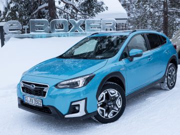 Een blauwe Subaru XV e-Boxer geparkeerd in een besneeuwd landschap.