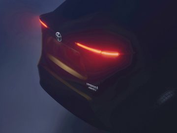 Een close-up van de achterkant van een Toyota-auto met opvallende LED-achterlichten, verlicht bij weinig licht.