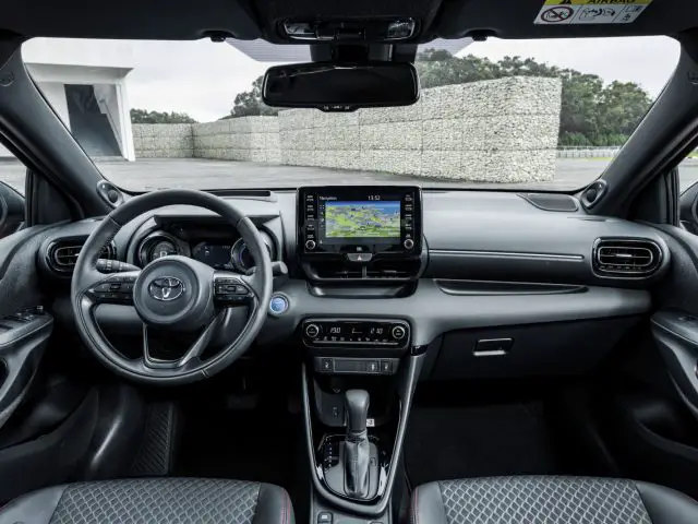 Binnenaanzicht van een Toyota Yaris met het stuur, het dashboard, de middenconsole en het infotainmentsysteem.