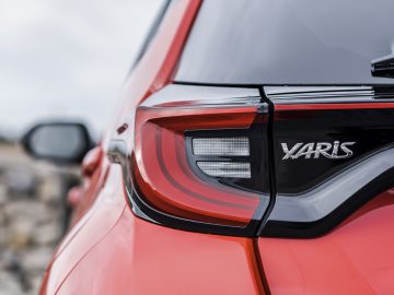 Close-up van het achterlicht en het naamplaatje van een Toyota Yaris.