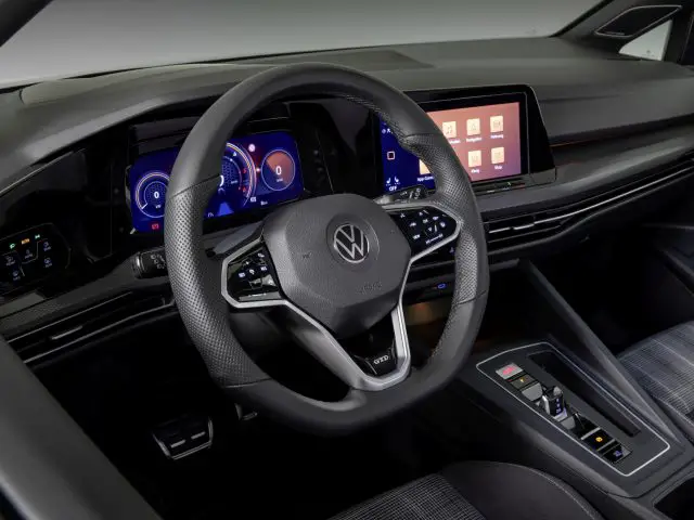 Binnenaanzicht van de Volkswagen Golf GTI, met de nadruk op het stuur en de digitale dashboarddisplays.