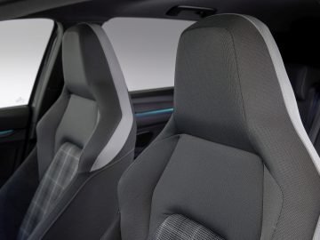 Modern Volkswagen Golf GTI-interieur met met stof beklede voorstoelen en zicht op het dashboard.