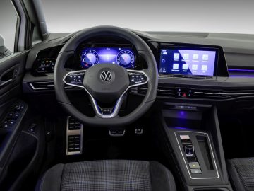 Modern Volkswagen Golf GTI-interieur met digitaal dashboard en touchscreen-infotainmentsysteem.