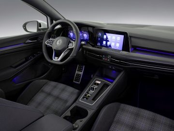 Modern Volkswagen Golf GTI-interieur met digitaal dashboard en middenconsole met touchscreen.