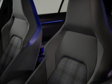 Modern Volkswagen Golf GTI-interieur gericht op sportieve stoffen stoelen met blauwe sfeerverlichting.