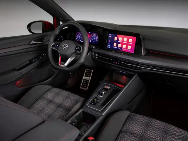 Modern Volkswagen Golf GTI interieur met digitaal dashboard en touchscreen display.