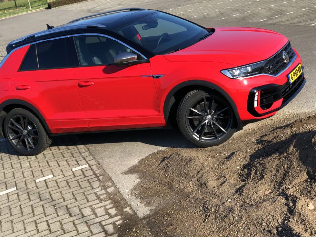 Rode Volkswagen T-Roc R geparkeerd op een verhard terrein naast een klein hoopje aarde.