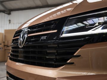 Close-up van een Volkswagen Transporter-grille met een logo en ABt-badge.