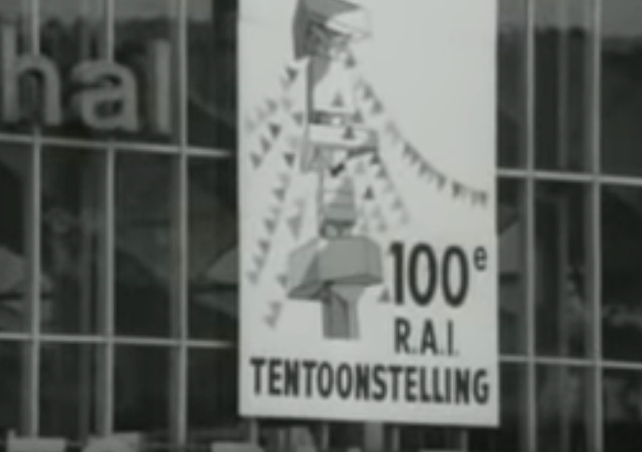 Zwart-witfoto van een poster voor de 100e AutoRAI-tentoonstelling.