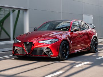 Rode Alfa Romeo Giulia GTA in beweging op een stedelijke weg.