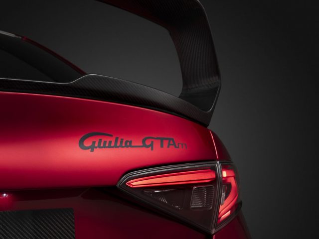 Close-up van een rode Alfa Romeo Giulia GTA met een koolstofvezelspoiler.