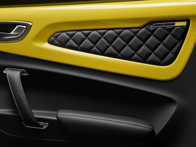 Luxe autodeurinterieur met zwart leer met gewatteerde stiksels en Alpine A110 gele accenten.