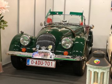 Vintage groene cabriolet te zien op het Antwerp Classic Salon 2020 met vlaggen aan de voorkant.