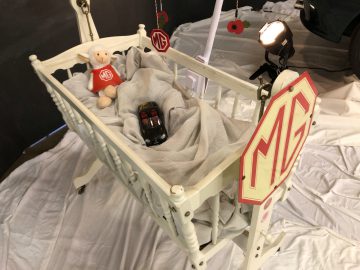 Vintage babybedje van het merk mg met thema-accessoires en een speelgoedauto van het Antwerp Classic Salon 2020.