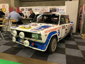 Een vintage rallyauto met emblemen te zien op het Antwerp Classic Salon 2020.