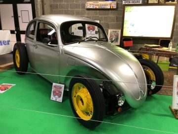 Aangepaste vintage auto tentoongesteld op Antwerp Classic Salon 2020 met zilveren carrosserie en gele wielen.
