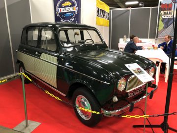 Vintage zwarte en groene auto te zien op de tentoonstelling Antwerp Classic Salon 2020 met toeschouwers op de achtergrond.