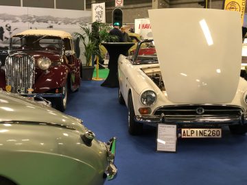 Klassieke auto's te zien op de indoortentoonstelling Antwerp Classic Salon 2020, met open motorkappen voor bezichtiging.