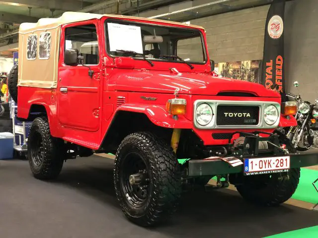 Een rode Toyota Land Cruiser met offroad-aanpassingen te zien op het indoorevenement Antwerp Classic Salon 2020.