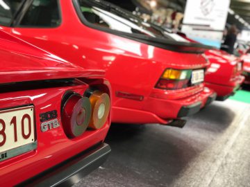Een close-up van de achterlichten en achterprofielen van twee rode klassieke sportwagens tentoongesteld op het Antwerp Classic Salon 2020.