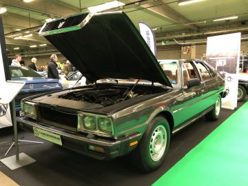 Vintage groene sedan met open kap te zien op de autoshow Antwerp Classic Salon 2020.