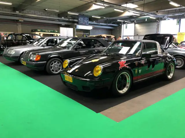 Een klassieke Porsche-sportwagen te zien op het Antwerp Classic Salon 2020, naast andere vintage voertuigen.