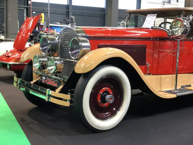 Vintage rode en beige auto met open motorkap tentoongesteld op de tentoonstelling Antwerp Classic Salon 2020.