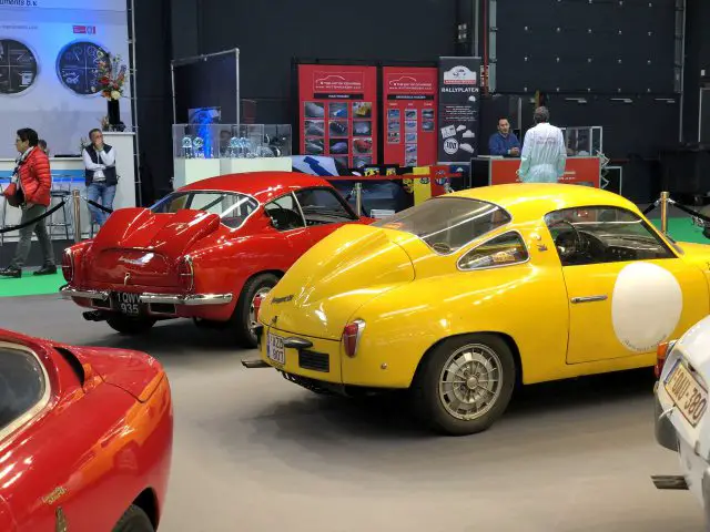 Klassieke auto's te zien op het Antwerp Classic Salon 2020, een binnententoonstelling waarbij bezoekers de voertuigen bekijken.