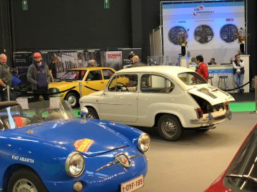 Een oldtimertentoonstelling op het Antwerp Classic Salon 2020 waarbij bezoekers de tentoongestelde klassieke Fiat-modellen observeren.