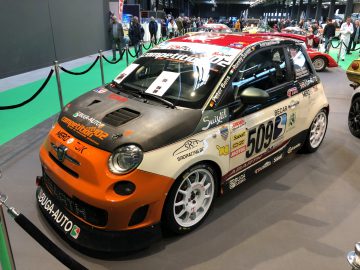 Een race-gemodificeerde Fiat 500 versierd met sponsorstickers die worden getoond op het indoortentoonstellingsevenement Antwerp Classic Salon 2020.