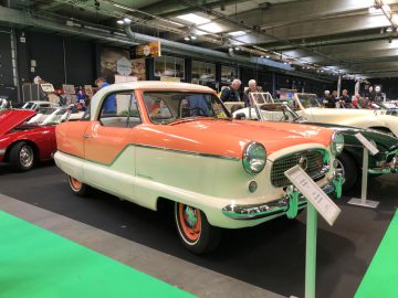 Een vintage tweekleurige auto te zien op het Antwerp Classic Salon 2020, waar bezoekers verschillende modellen kunnen bekijken.