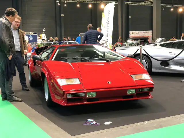 Een rode Lamborghini Countach te zien op het Antwerp Classic Salon 2020 met toeschouwers.