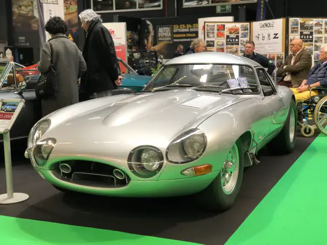 Een vintage zilveren coupé tentoongesteld op het Antwerp Classic Salon 2020 met toeschouwers op de achtergrond.