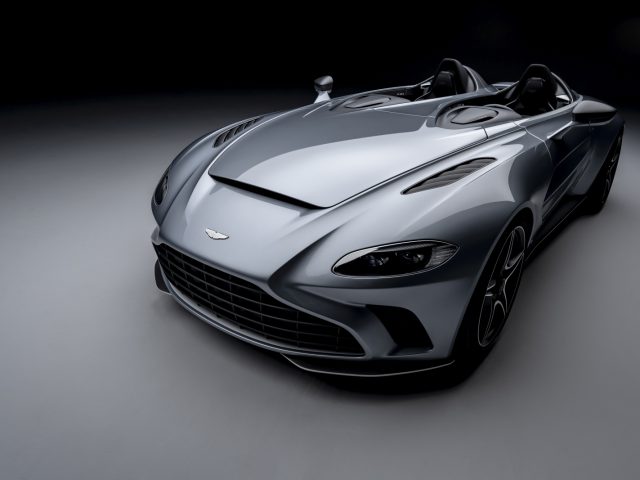 Slanke Aston Martin V12 Speedster converteerbare sportwagen op een donkere achtergrond.