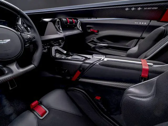 Binnenaanzicht van een Aston Martin V12 Speedster met de nadruk op de bestuurderscockpit en koolstofvezeldetails.