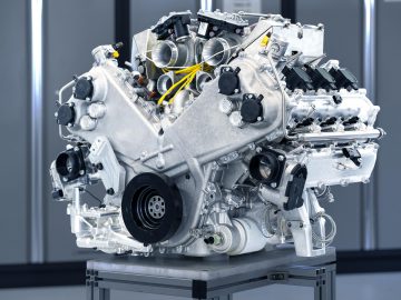Een complexe meercilinder Aston Martin Valhalla-motor tentoongesteld op een standaard met verschillende componenten zichtbaar.