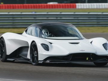 Een witte Aston Martin Valhalla krachtige sportwagen in beweging op een racecircuit.