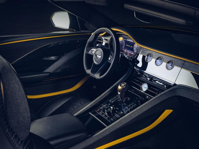 Luxe Bentley Mulliner Bacalar-interieur met zwarte en gele accenten, voorzien van een lederen stuur en modern dashboard.