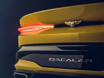 Achterdetail van een gele Bentley Mulliner Bacalar met het achterlicht en de modelnaam.