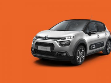 Een grijze Citroën C3 SUV op een oranje achtergrond.
